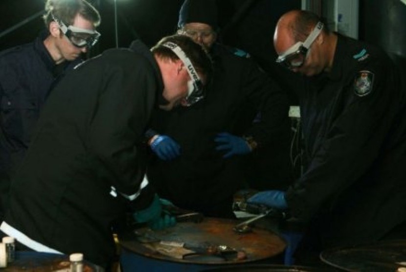 Tim forensik memeriksa drum minyak yang dipenuhi kokain pada tahun 2011.