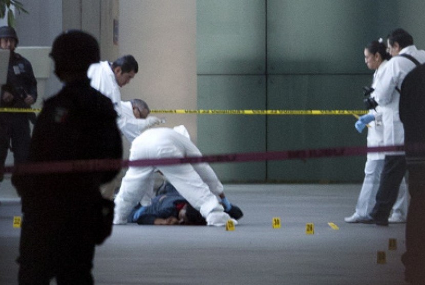 Tim Forensik menyaksikan salah satu polisi korban tewas dalam insiden baku tembak di Bandara Meksiko City