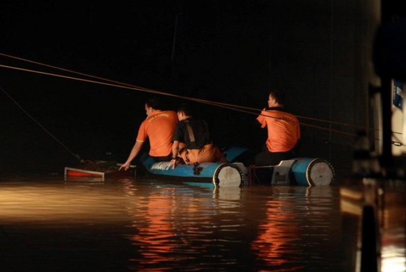 Tim gabungan berupaya melakukan pencarian korban banjir di basement Plaza UOB, Jakarta, Jumat (18/1) malam. 