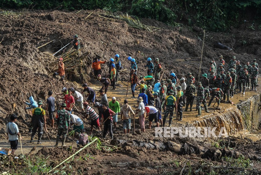 Tim gabungan dari BPBD, Basarnas, Polri, TNI, Tagana dan warga membersihakan material tanah longsor yang menimbun jalan di Desa Santanamekar, Kecamatan Cisayong, Kabupaten Tasikmalaya, Jawa Barat, Senin (2/3/2020).