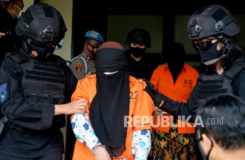 Tim gabungan Detasemen Khusus (Densus) 88 Antiteror Mabes Polri dan Brimob Polda Sulsel menggiring tersangka teroris saat akan diberangkatkan ke Jakarta di Bandara lama Sultan Hasanuddin, Kabupaten Maros, Sulawesi Selatan, Kamis (4/2/2021). Sebanyak 19 tersangka kasus terorisme jaringan Jamaah Ansharut Daulah (JAD) yang ditangkap Tim Densus 88 Antiteror di Makassar tersebut diterbangkan ke Jakarta untuk menjalani pemeriksaan lanjutan. 