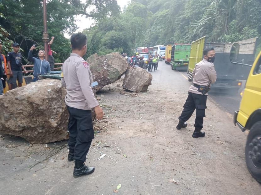 Tim gabungan melakukan evakuasi dan pembersihan longsoran tanah dan batu di Jl Raya Cadas Pangeran.