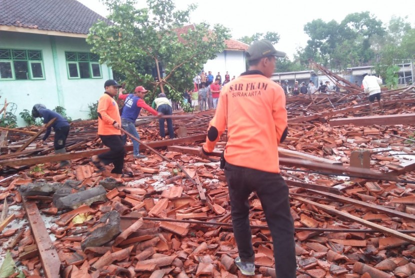 Tim gabungan membersihkan reruntuhan aula SMK Negeri 1 Miri Kabupaten Sragen, Jawa Tengah, Kamis (21/11). Bangunan tersebut roboh terkena angin kencang yang bersamaan dengan hujan lebat pada Rabu (20/11) sore.