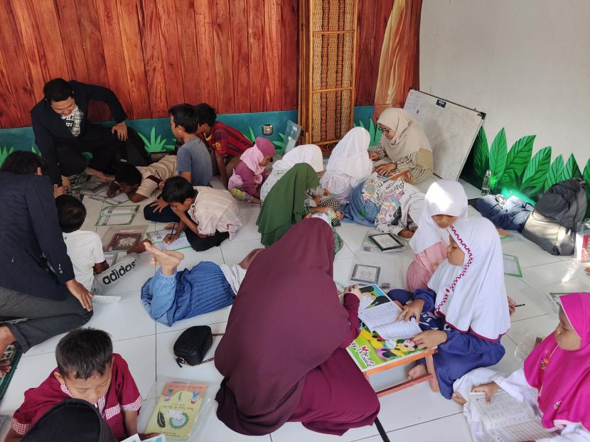 Tim Gerakan Nasional Revolusi Mental (GNRM) Universitas Al Azhar Indonesia  (UAI) mengajarkan baca tulis Alquran kepada  anak-anak Kampung Gasong, Menteng, Jakarta.