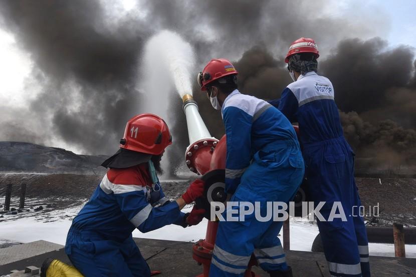 Tim HSSE & Fire Fighter Pertamina berupaya memadamkan api di lokasi insiden terbakarnya tangki penyimpan BBM di Kilang Balongan RU VI, Indramayu, Jawa Barat, Rabu (31/3/2021).