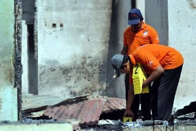  Tim INAFIS Polda Sulteng melakukan olah TKP di sebuah rumah yang terbakar setelah terjadinya bentrokan warga antar desa di Palu, Sulawesi Tengah, Rabu (4/4). 