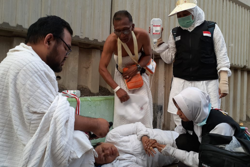 Tim Kesehatan Haji Indonesia (TKHI) memberikan pertolongan pertama kepada jamaah haji yang pingsan di jalur Jamarat-Mina, Ahad (11/8). Jamaah tersebut mengalami dehidrasi dan kelelahan usai melempar jumrah di Jamarat. 
