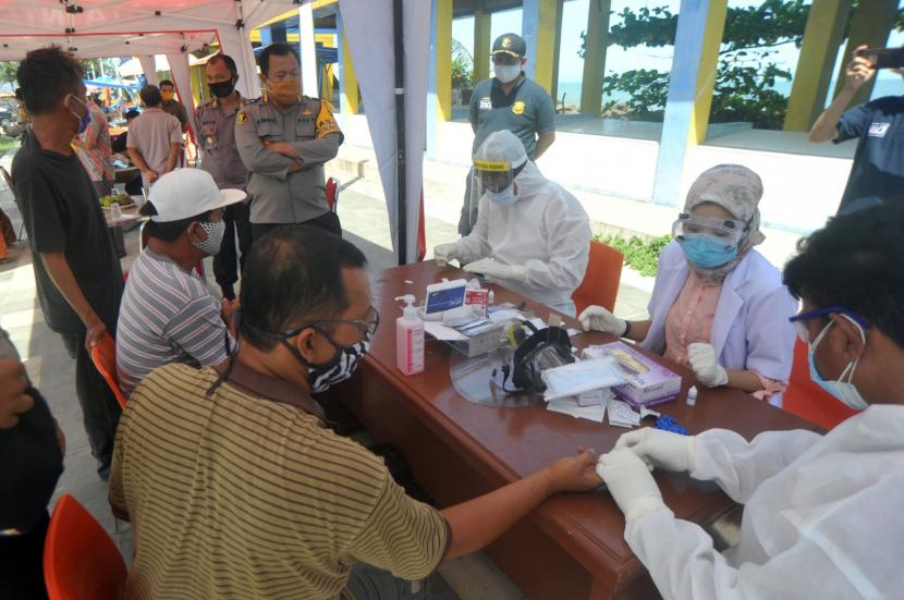Tim kesehatan Polda Sumbar melakukan rapid test di pasar ikan pantai Purus, Padang, Sumatera Barat, Kamis (28/5/2020). Polda Sumbar menggelar rapid test terhadap nelayan dan pedagang ikan di kawasan tersebut untuk mencegah penyebaran COVID-19.