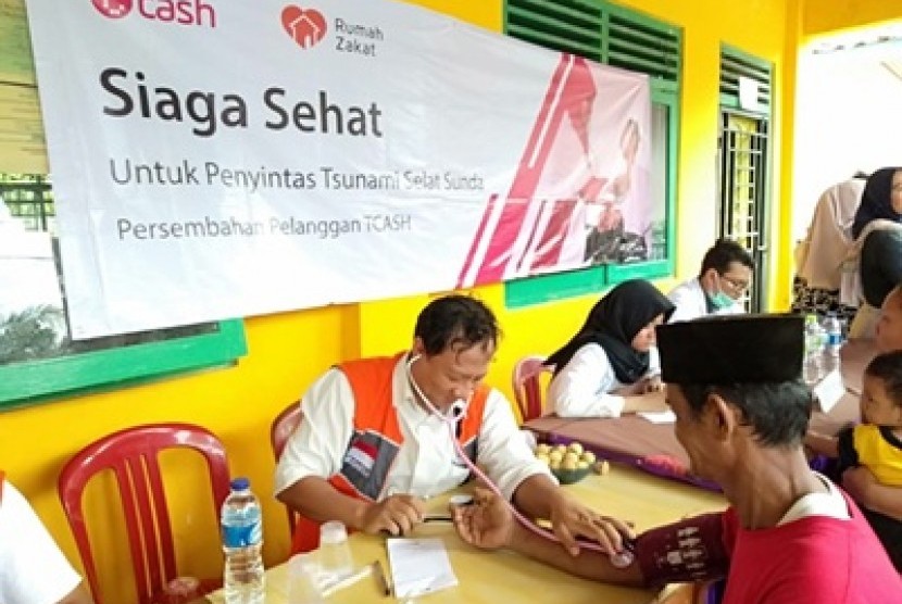 Tim kesehatan TCash dan Rumah Zakat memberikan bantuan layanan kesehatan gratis untuk masyarakat korban tsunami selat sunda, Ahad (10/2).