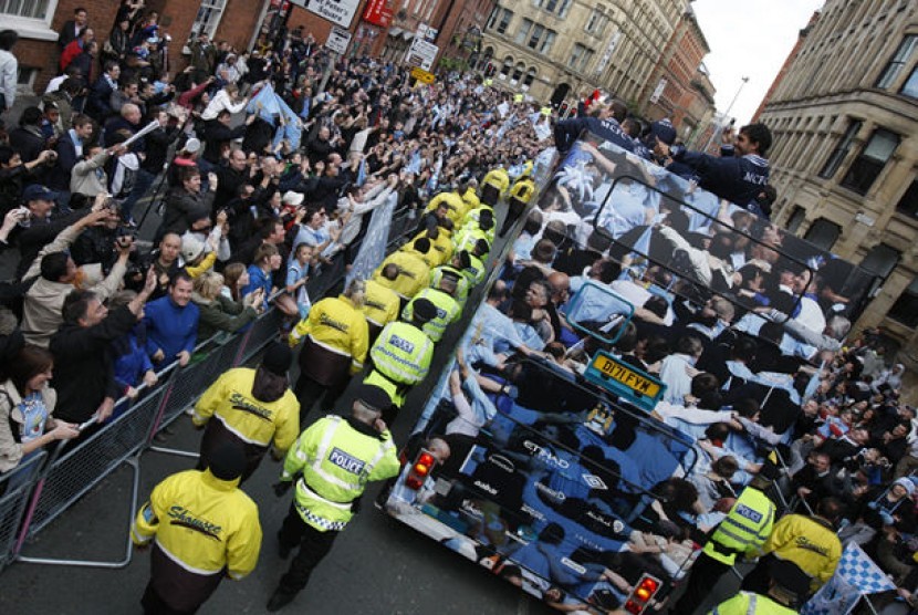 Tim Manchester City menggelar pawai tropi kemenangan di Manchester City. Tampak citizen--julukan suporter City--memenuhi sudut jalan dengan atribut kebanggan klub berwaran biru