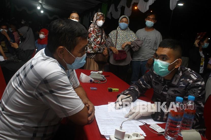 Tim medis dari TNI AL melayani pertanyaan warga saat gebyar vaksinasi di halaman Kantor Gubernur Kalbar di Pontianak, Kalimantan Barat, Ahad (14/11/2021) malam. Dinas Kesehatan Provinsi Kalbar mencatat hingga Sabtu (13/11/2021) sebanyak 1.794.170 orang telah menjalani vaksinasi COVID-19 untuk penyuntikan tahap pertama, 1.052.176 orang untuk penyuntikan tahap kedua dan 21.786 orang untuk tahap ketiga di wilayah Kalimantan Barat.