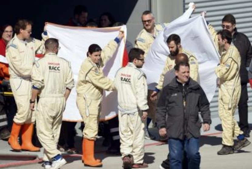 Tim medis mengevakuasi Fernando Alonso ke dalam helikopter untuk diterbangkan ke RS, usai kecelakaan saat ujicoba di Spanyol, Ahad (22/2).