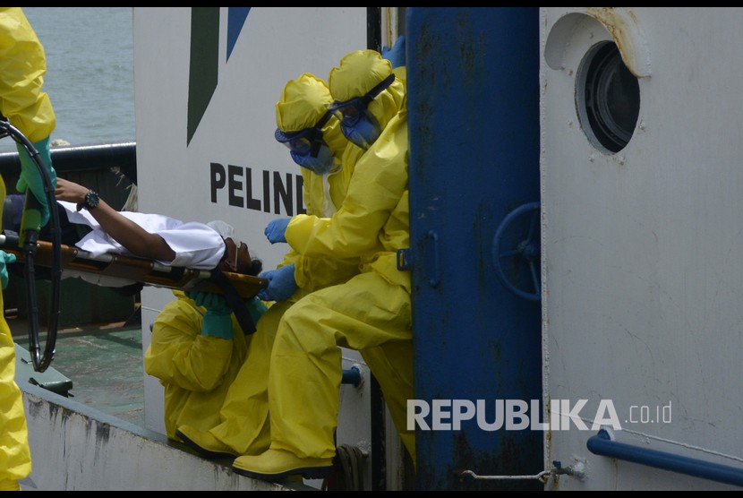 Tim medis mengevakuasi seorang warga negara asing (WNA) terjangkit virus corona (COVID-19) turun dari kapal saat simulasi penanganan virus Corona di Pelabuhan Sukarno Hatta, Makassar.