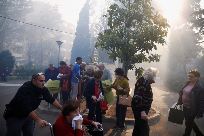 Tim medis mengevakuasi warga akibat kebakaran hutan di utara kota Haifa, Israel 24 November 2016.