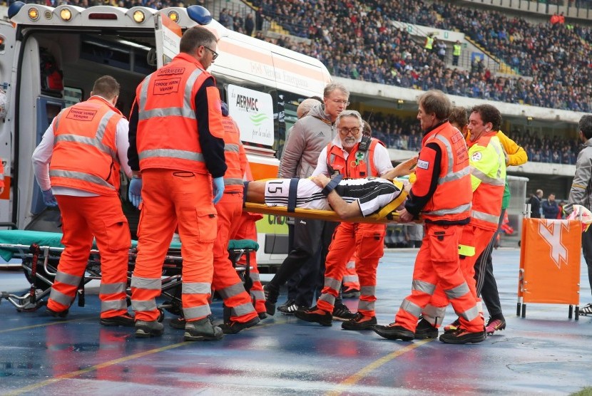 Tim medis menggotong bek Juventus, Andrea Barzagli ke ambulans setelah menderita cedera bahu pada laga Serie A lawan Chievo Verona di stadion Bentegodi, Ahad (6/11). Laga berakhir kemenangan untuk Juventus, 2-1.