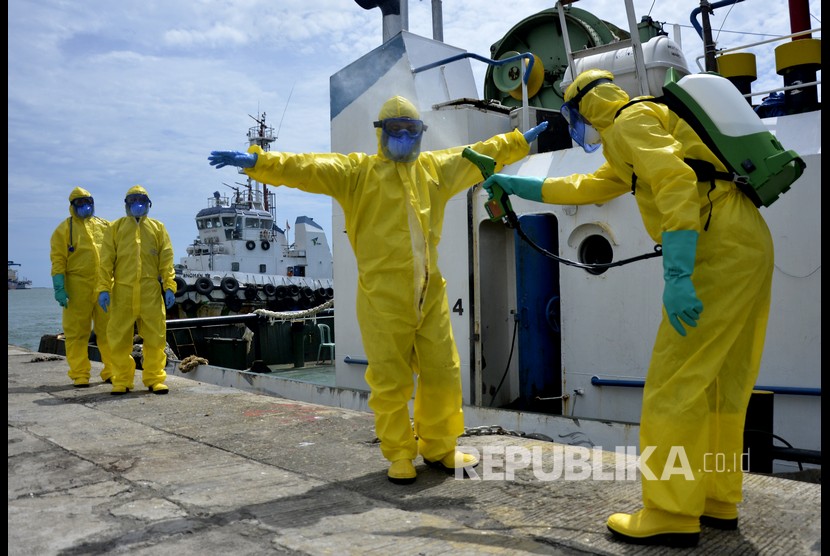 Tim medis menyemprotkan cairan disinfektan pada rekannya usai mengevakuasi seorang warga negara asing (WNA) terjangkit virus corona (COVID-19) turun dari kapal saat simulasi penanganan virus Corona di Pelabuhan Sukarno Hatta, Makassar, Sulawesi Selatan, Selasa (10/3/2020). 