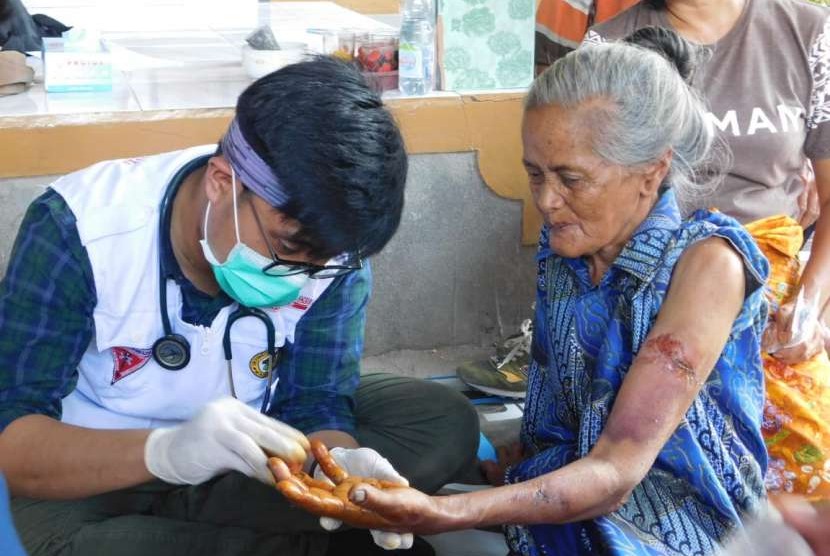 Tim medis relawan ACT mengobati Ina Dasiah (70 tahun) yang tertimpa lemari akibat gempa bumi di pos kesehatan ACT di Desa Bentek, Kecamatan Gangga, Kabupaten Lombok Utara, Nusa Tenggara Bara, Rabu (8/8). 