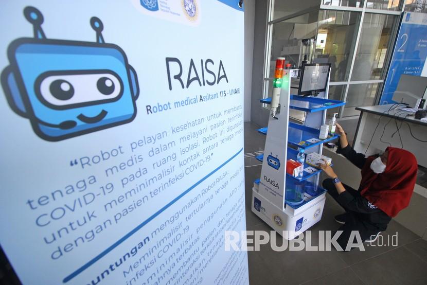 Tim peneliti menyiapkan makanan dan obat-obatan yang dibawa Robot Medical Assistant ITS-UNAIR (RAISA) saat diuji coba di Gedung Pusat Robotika Institut Teknologi Sepuluh Nopember (ITS), Surabaya, Jawa Timur, Selasa (14/4/2020). Robot RAISA yang dibuat dari hasil kerja sama ITS dan Rumah Sakit Universitas Airlangga (RSUA) tersebut guna membantu tenaga kesehatan (nakes) dalam melakukan pelayanan sekaligus mengurangi interaksi langsung dengan pasien COVID-19. 