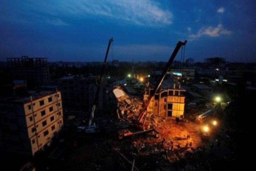 Tim penyelamat berusaha mencari korban runtuhan gedung Rana Plaza, dekat Dhaka, Bangladesh, Tercatat 380 orang tewas.
