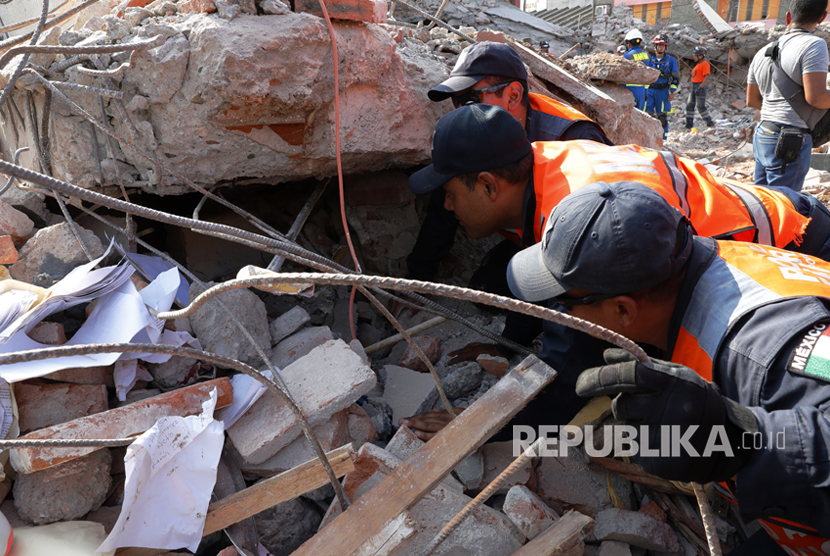 Tim penyelamat berusaha mengevakuasi korban dari bangunan yang runtuh akibat gempa 8,2 SR  di kota Juchitan, Oaxaca, Meksiko,  Sabtu (9/9).  