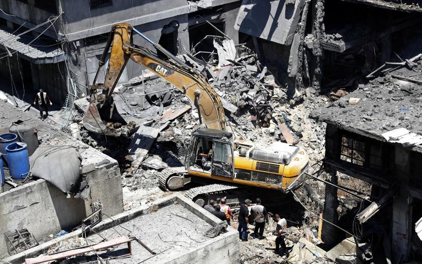 Tim penyelamat dan personel keamanan Palestina memeriksa lokasi ledakan ketika penggali mekanis bekerja untuk menghilangkan puing-puing, di Kota Gaza, Gaza, Kamis, 22 Juli 2021. Sedikitnya satu orang tewas dan 10 terluka Kamis ketika sebuah ledakan menghancurkan sebuah rumah di pasar yang populer, kata kementerian dalam negeri.