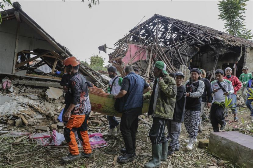 Tim penyelamat dan warga desa membawa jenazah korban saat pemakaman di desa yang terkena gempa 5,6 SR di Cianjur, Jawa Barat, Jumat, 25 November 2022. 