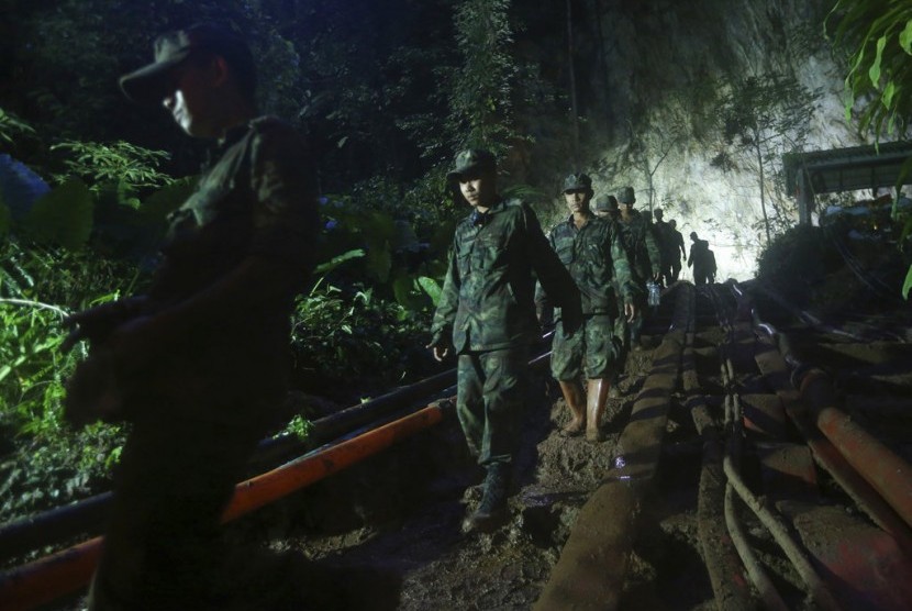 Tim penyelamat di depan pintu masuk gua Tham Luang di Mae Sai, Chiang Rai, Thailand, Ahad (1/7). Petugas terus berupaya mencari tim sepak bola yang hilang.