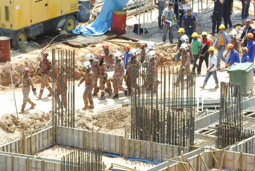 Tim penyelamat Malaysia membawa jasad korban tanah longsor di lokasi konstruksi di Penang, Malaysia, Ahad (22/10). Tanah longsor tersebut menewaskan sejumlah pekerja asingm termasuk dari Indonesia.