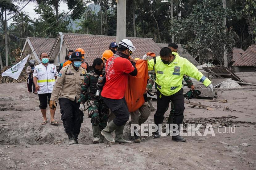 Tim penyelamat membawa jenazah korban di kawasan yang terkena dampak erupsi Gunung Semeru di Lumajang, Jawa Timur,  Senin (6/12.). Gunung meletus pada 04 Desember, menewaskan sedikitnya 14 orang dan menyebabkan puluhan lainnya luka-luka. 
