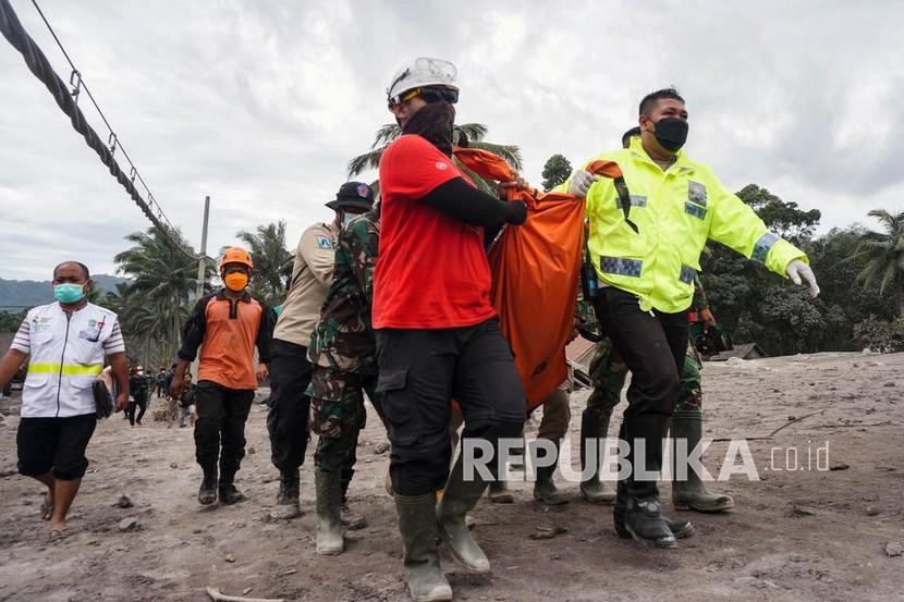 Tim penyelamat membawa jenazah korban di kawasan yang terkena dampak erupsi Gunung Semeru di Lumajang, Jawa Timur,  Senin (6/12.). Gunung meletus pada 04 Desember, menewaskan sedikitnya 14 orang dan menyebabkan puluhan lainnya luka-luka. 