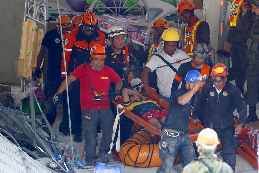 Tim penyelamat membawa korban selamat gempa di Porac, Provinsi Pampang, Manila, Filipina, Selasa (23/4).