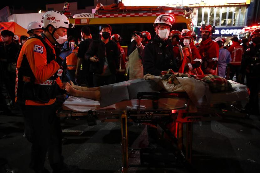 Tim penyelamat memindahkan korban dengan tandu di distrik Itaewon Seoul setelah terinjak-injak saat pesta Halloween di Seoul, Korea Selatan, 30 Oktober 2022.