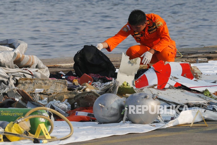 Seorang anggota Basarnas memeriksa puing pesawat Lion Air JT 610 pascakecelakaan di Pelabuhan Tanjung Priok, Jakarta, Senin (29/10/2018).