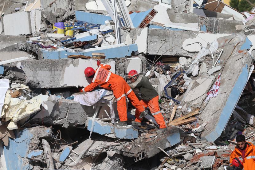 Tim penyelamat mencari korban selamat di antara puing-puing sebuah bangunan yang hancur akibat gempa hebat di Kahramanmaras, Turkiye.