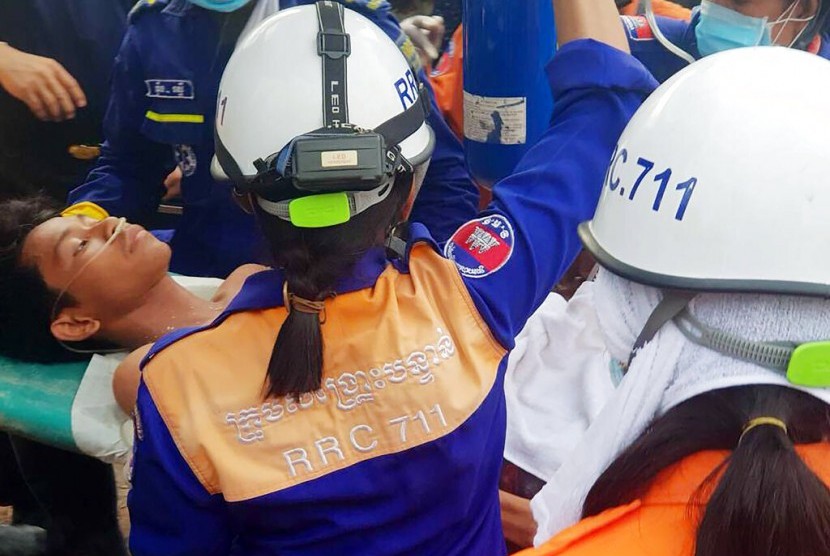Tim penyelamat mengevakuasi korban selamat bangunan ambruk di Preah Sihanouk, Kamboja, Senin (24/6).