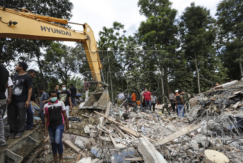  Tim penyelamat  menggunakan excavator untuk mencari korban setelah gempa bumi berkekuatan 6,4 SR yang melanda kabupaten Pidie Jaya, Aceh, Rabu (7/12). 