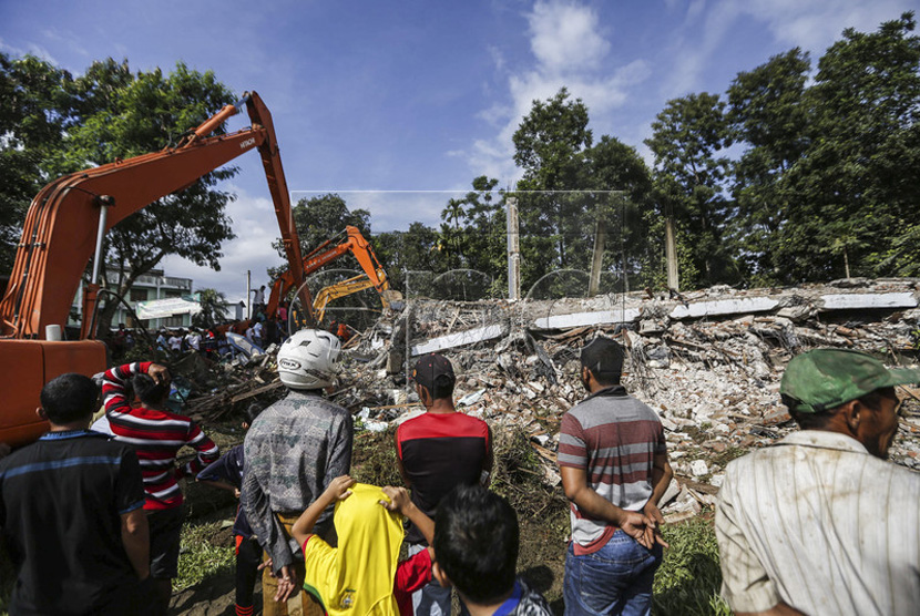  Tim penyelamat  menggunakan excavator untuk mencari korban setelah gempa bumi berkekuatan 6,4 SR yang melanda kabupaten Pidie Jaya, Aceh, (7/12). 