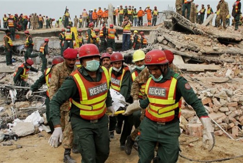 Tim penyelamat Pakistan membawa jenazah korban bangunan runtuh di Lahore, Pakistan, Jumat, 6 November 2015. 