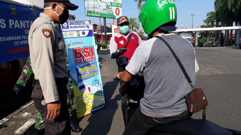 Tim Progam  BSI Peduli membagikan masker dan hand sanitizer  di sekitar Posko (check point) perempatan RS  Puri Cinere , Jakarta Selatan.