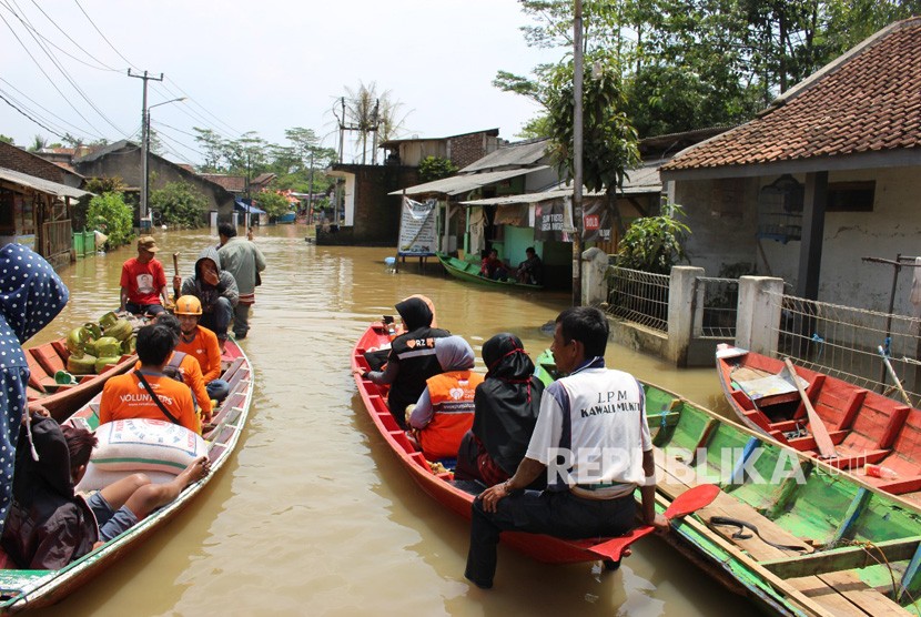Tim Relawan Rumah Zakat dan BIJB menyusuri perkampungan warga yang terendam banjir untuk menyalurkan bantuan di   Kabupaten Bandung.