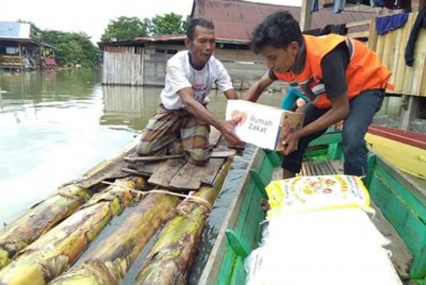 Tim Relawan Rumah Zakat Makassar melakukan penyaluran kepada korban banjir di Kecamatan Tanasitolo, Sulawesi Selatan, Senin (2/7). 