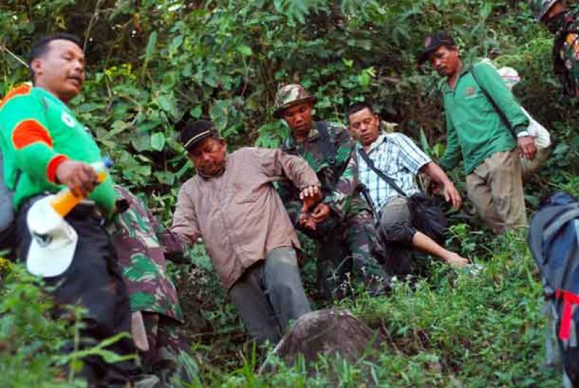  Tim SAR bersama TNI menuntun Ketua DPRD Kabupaten Solok, Syafri Datuak Siri Marajo (dua kiri) menuruni bukit, saat evakuasi 21 peserta napak tilas di hutan Patamuan, Pauh, Padang, Sumbar, Jumat (31/5).