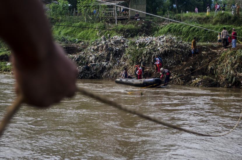 Tim SAR gabungan membantu pelajar menaiki perahu karet untuk menyebrangi Sungai Cimanuk, Garut, Jawa Barat, Selasa (19/7/2022). Warga di kawasan tersebut terpaksa menggunakan perahu karet yang disediakan oleh Tim SAR gabungan Polri, TNI dan Badan Penanggulangan Bencana Daerah (BPBD) Garut untuk akses penyebrangan khususnya menuju sekolah akibat rusaknya jembatan penghubung antar kecamatan dampak dari banjir bandang Sungai Cimanuk beberapa waktu lalu. 
