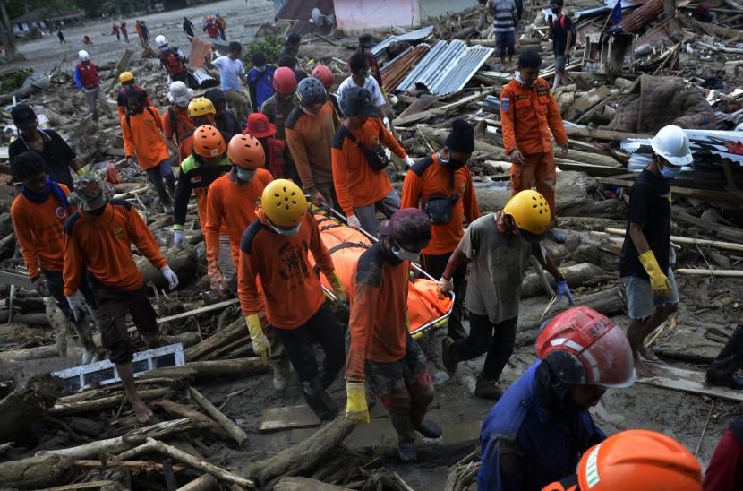 Tim SAR gabungan mengangkat kantong jenazah korban banjir bandang di Desa Radda, Kabupaten Luwu Utara, Sulawesi Selatan.