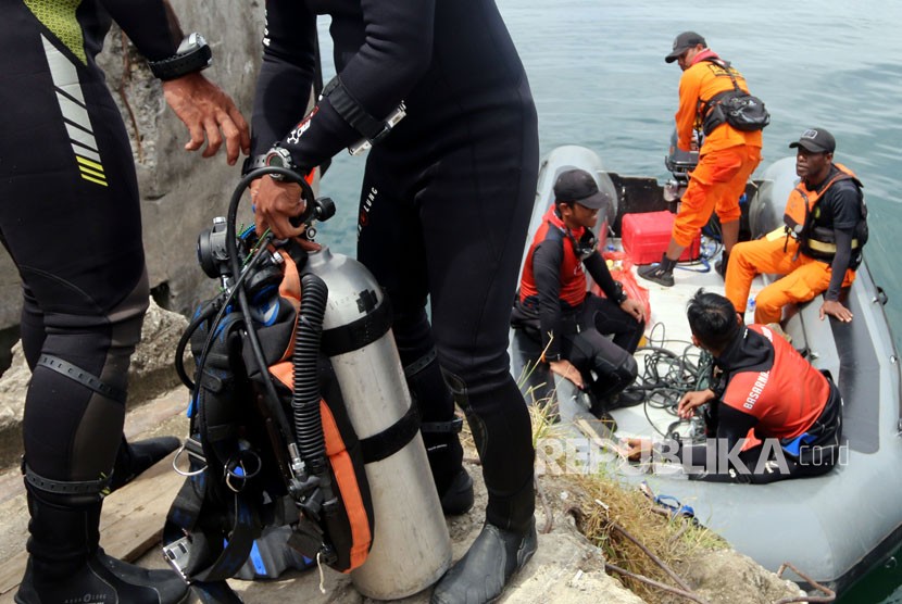 Tim SAR gabungan mengangkat perlengkapan selam saat pencarian korban tenggelamnya KM Sinar Bangun, di Danau Toba, Simalungun, Sumatera Utara, Ahad (24/6).