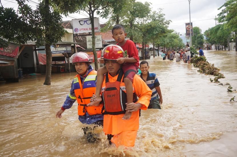 Tim SAR gabungan mengevakuasi anak-anak yang rumahnya terjebak banjir bandang di wilayah Kelurahan Kelutan, Kota Trenggalek, Jawa Timur, Selasa (18/10/2022). Banjir bandang kembali menerjang wilayah pesisir selatan Trenggalek, Sabtu (5/11/2022) malam hingga Ahad pagi.