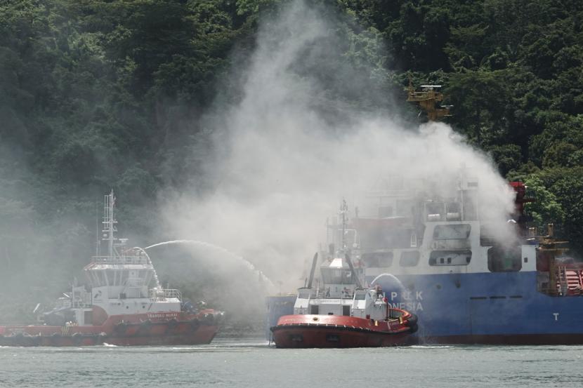 Tim SAR gabungan menggunakan Tugboat melakukan pemadaman kapal kargo Soemantri Brodjonegoro yang terbakar di perairan Teluk Penyu, Cilacap, Jawa Tengah, Rabu (1/12/2021). Kapal kargo Soemantri Brodjonegoro bermuatan pupuk dengan 26 ABK ini mengalami kebakaran pada Rabu (1/12/2021) pukul 07.15 WIB. 