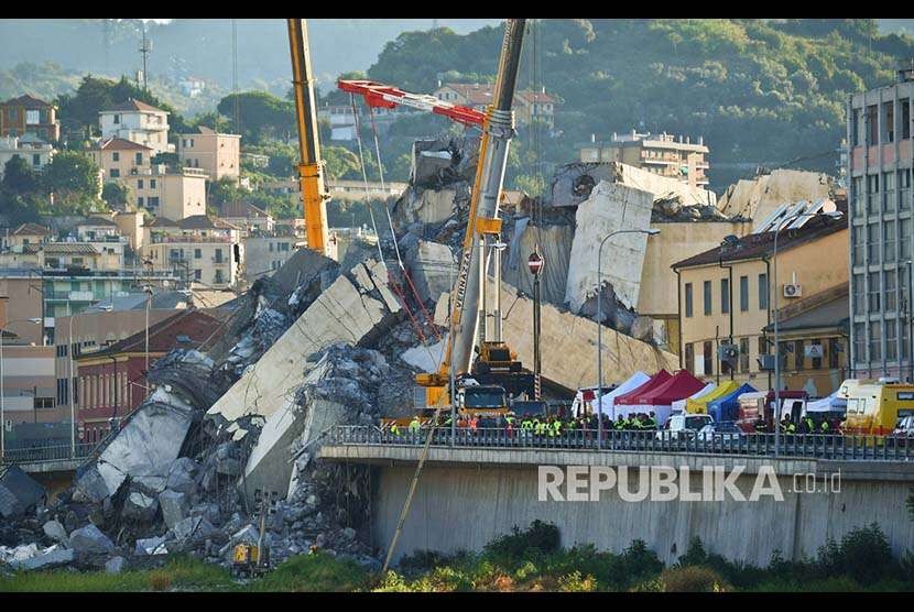 Tim SAR mencari korban di antara  reruntuhan masif  jembatan jalan raya Morandi yang rubuh  di Kota Genoa Italia, Rabu (15/8), Sedianya jembatan ini menggantung setinggi hampir 90 metet di atas kota pelabuhan Genoa.