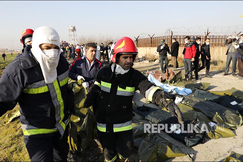 Tim SAR mengevakuasi korban pesawat Ukrainian dengan 176 penumpang yang jatuh di Shahedshahr, baratlaut Teheran, Iran Rabu (8/1).  
