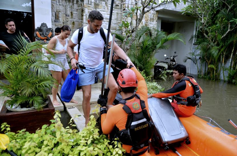 Tim SAR mengevakuasi wisatawan mancanegara (wisman) menggunakan perahu karet saat terjebak banjir di kawasan Seminyak, Badung, Bali, Sabtu (8/10/2022). Tim SAR gabungan mengevakuasi puluhan wisman dari sejumlah vila yang terendam banjir dengan ketinggian sekitar 1,5 meter di kawasan pariwisata itu akibat hujan yang mengguyur Bali sejak Jumat (7/10). 